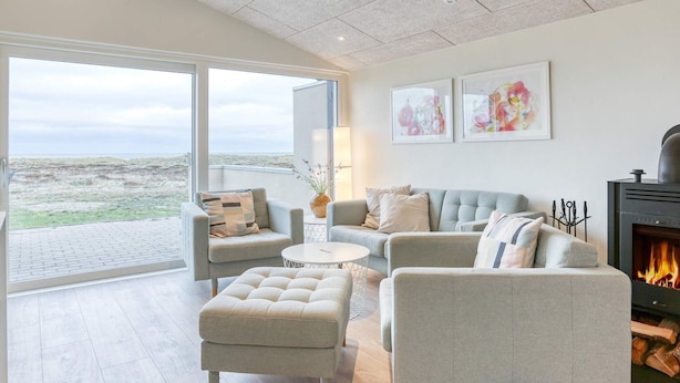 A modern living room with a grey sofa set, a round coffee table, and a fireplace. - 6 Person Holiday Home in Laeso-by Traum (Læsø)