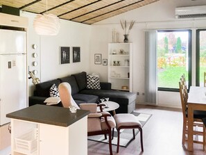 A modern living space with a kitchen area, a dining table, and a sofa. - 4 Star Holiday Home in Sydals (Sydals)