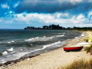 A beach with a red boat, a yellow boat, and a white boat on the sand. - 4 Star Holiday Home in Sydals (Sydals)