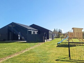 A modern building with a covered entrance and a play area with a slide. - 5 Star Holiday Home in Albaek (Aalbaek)