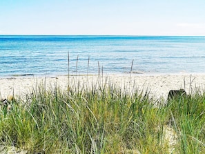 A beach with clear blue water and sandy shore.