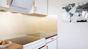 Una cocina con estufa, armarios y un mapa mundial en la pared.