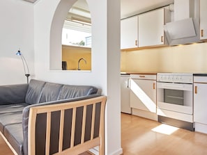 A modern kitchen with white cabinets, a built-in oven, and a countertop. - 4 Star Holiday Home in Allinge (Allinge)