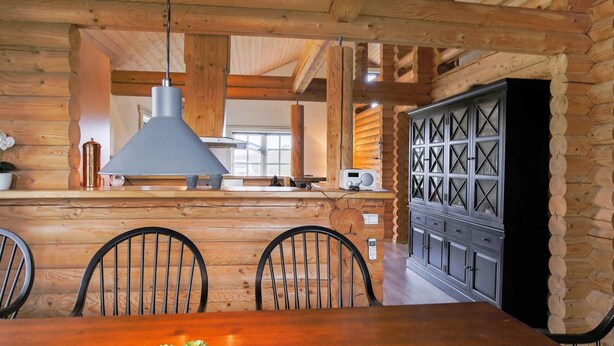 A wooden interior with a central island, black chairs, and a table with potted plants. - 10 Person Holiday Home in Vaeggerlose-by Traum (Vaeggerlose)