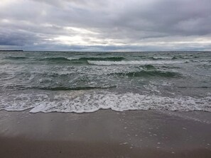 Une plage avec des vagues et un ciel nuageux.