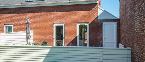 Un bâtiment en briques avec une façade blanche, une porte et une fenêtre.