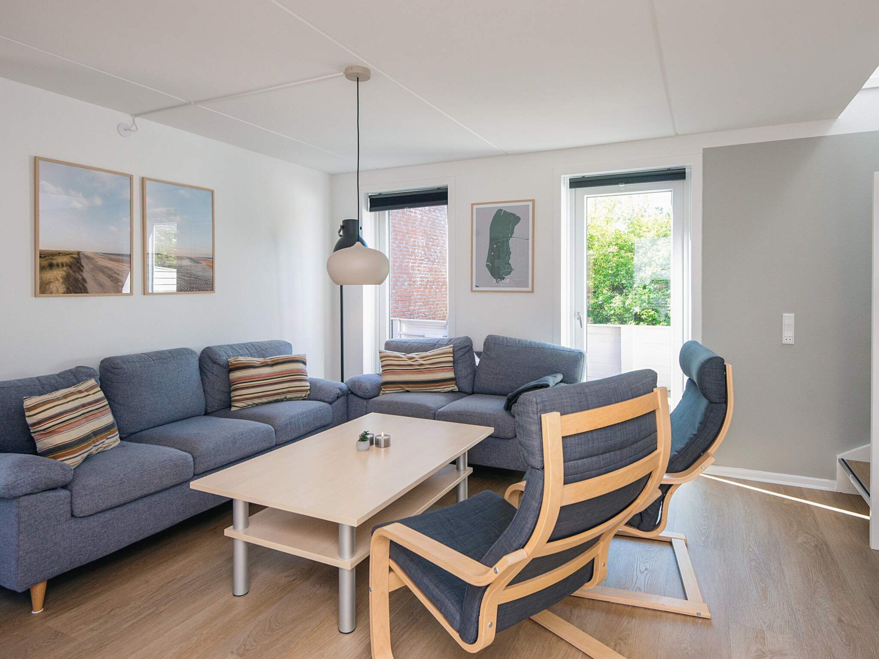 A modern living room with a sectional sofa, a wooden coffee table, and a rocking chair.