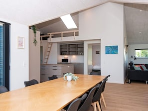 Et moderne interiør med spiseplads, køkken og opholdsstue.