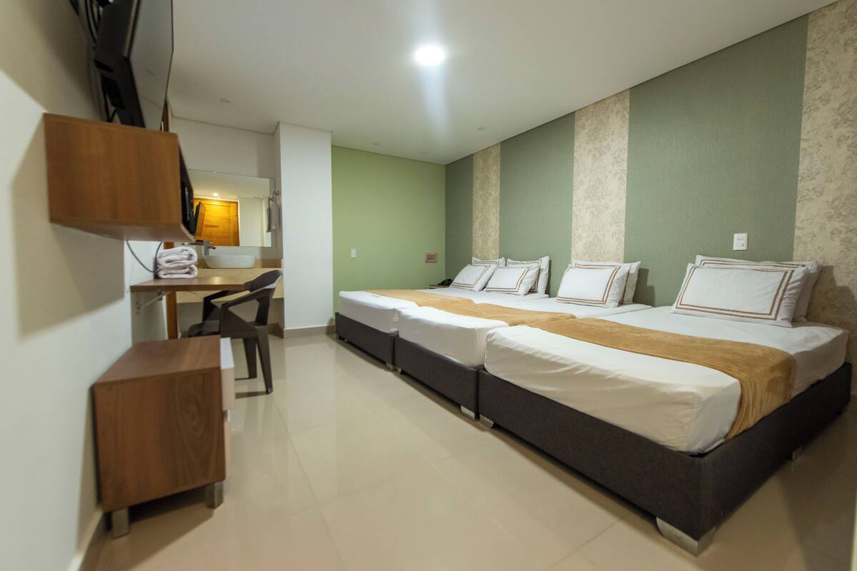 A hotel room with a bed, a desk, and a chair.