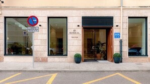 Entrada de hotel con un cartel de ‘no estacionar’, un letrero que indica una estancia máxima de 10 minutos, y el nombre del hotel ‘Boreal’ con ‘Viento Norte’ debajo.