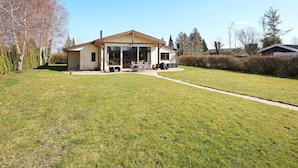 A single-story house with a patio, a chimney, and a large window. - 6 Person Holiday Home in Kirke Hyllinge (Kirke Hyllinge)
