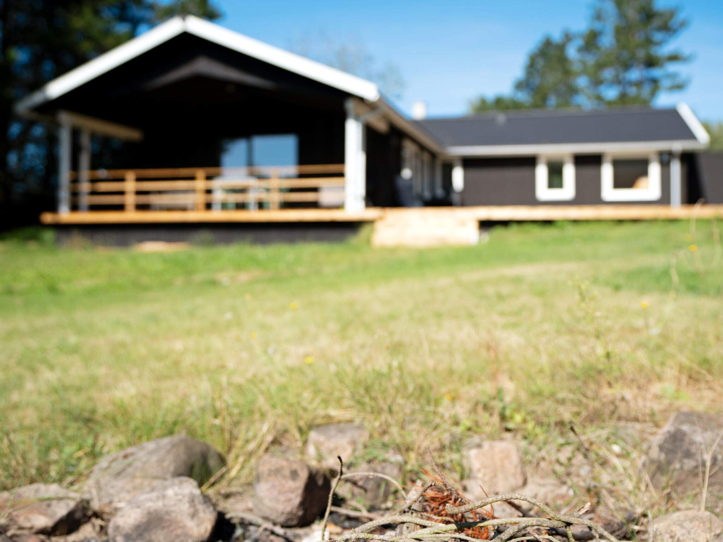 Une maison à deux étages avec une terrasse en bois et un garage.