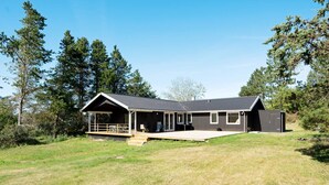 Une maison moderne dotée d’un porche couvert, d’une terrasse et d’un garage.