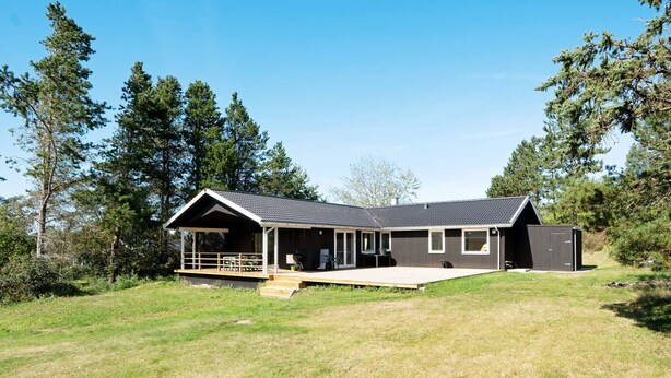 A modern house with a covered porch, a deck, and a garage.