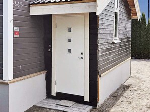 A small, single-story building with a white door and a small porch area.