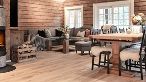 A cozy log cabin interior with a fireplace, a dining table, and comfortable seating. - 5 Star Holiday Home in Geiranger (Stranda)