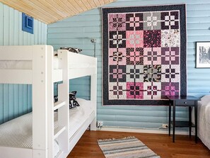 A room with a bunk bed, a quilt, a desk, and a chair. - 6 Person Holiday Home in Fjallbacka (Fjallbacka)