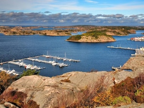 A marina with boats docked, surrounded by rocky terrain and distant islands. - 6 Person Holiday Home in Fjallbacka (Fjallbacka)