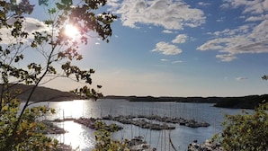 Een jachthaven met aangemeerde boten, omringd door bomen en een heldere lucht.