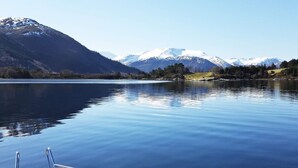 A boat on a calm lake with mountains in the background.
