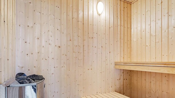 A sauna room with wooden walls and benches. - 5 Star Holiday Home in Vaeggerlose (Vaeggerlose)
