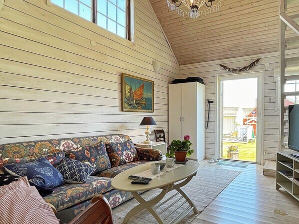 A cozy living room with a sofa, a coffee table, and a painting on the wall.