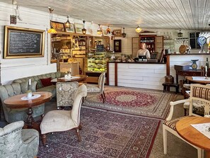 A cozy interior with a bar area, seating, and a display case. - 4 Star Holiday Home in Ellos (Ellos)