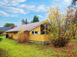 A yellow house with a sloped roof, a visible chimney, and a window. - 6 Person Holiday Home in Idestrup (Idestrup)