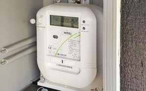 A white water heater with a digital display, installed in a corner with a metal railing. - 8 Person Holiday Home in Juelsminde (Horsens)