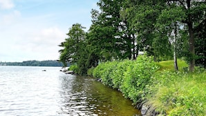 A calm lake with a grassy shoreline and trees. - 4 Person Holiday Home in Arboga (Arboga)