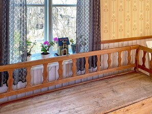 A wooden bench with a balustrade, a small potted plant, and a miniature house model on a windowsill. - 4 Person Holiday Home in Arboga (Arboga)