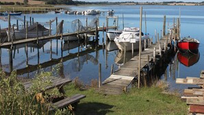 Un lago tranquilo con varios barcos amarrados a muelles de madera.