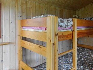 A bunk bed with a patterned mattress and a wooden headboard. - 6 Person Holiday Home in Holsljunga (Holsljunga)