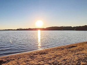 A beach with a calm sea and a clear sky. - 6 Person Holiday Home in Holsljunga (Holsljunga)