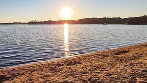 Una spiaggia con un mare calmo e un cielo sereno.
