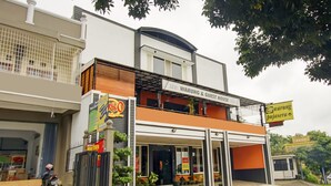 Um edifício de dois andares com uma placa indicando '180 Warung & Guest House'.