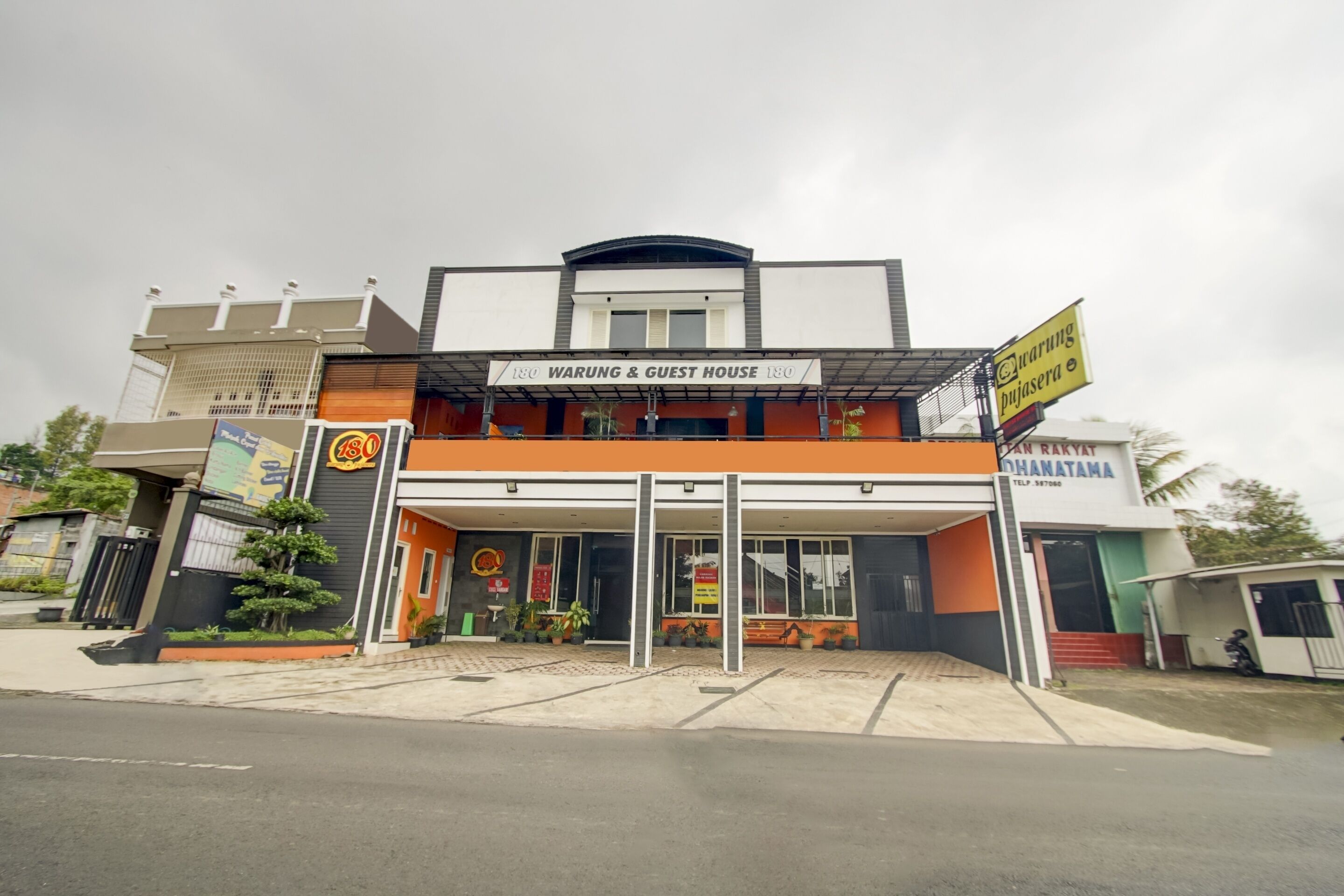 A building with a sign reading "Warung & Guest House 180".