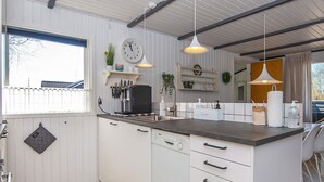 A modern kitchen with white cabinetry, a Bosch dishwasher, a sink, and a window with a view of a house. - 4 Person Holiday Home in Hemmet (Hemmet)