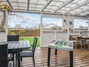 A covered outdoor area with a foosball table, a dining table, and chairs. - 8 Person Holiday Home in Haderslev (Haderslev)