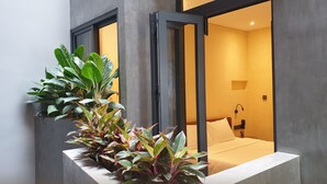A modern hotel room with a bed, a bedside table, and a large window. - Shelter Stay Da Nang (Da Nang)