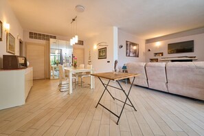 Un salon moderne avec un canapé, une table à manger et un téléviseur.