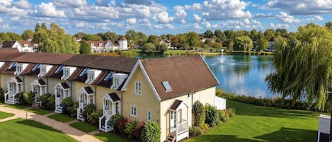 A row of houses with a lake and trees in the background.