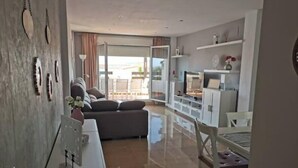 Una sala de estar moderna con un sofá, una mesa de comedor y una zona de cocina.