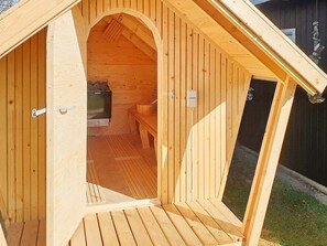 A wooden sauna with a bench and a television.