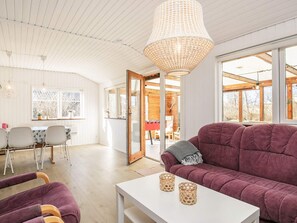 A modern interior with a sofa, a table, and a hanging light fixture. - 4 Star Holiday Home in Vinderup (Vinderup)