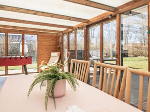 A sunroom with a table, chairs, and a foosball table. - 4 Star Holiday Home in Vinderup (Vinderup)