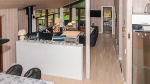 A modern cabin interior with a dining area, kitchen, and living space. - 6 Person Holiday Home in Laeso-by Traum (Læsø)