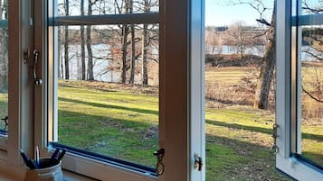 A window with a view of a grassy field and trees.