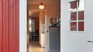 Ein Flur, der zu einem Zimmer mit Heizkörper, Stuhl und Tisch führt.