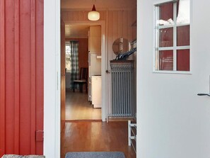 A hallway leading to a room with a radiator, a chair, and a table. - 7 Person Holiday Home in Oxaback (Öxabäck)